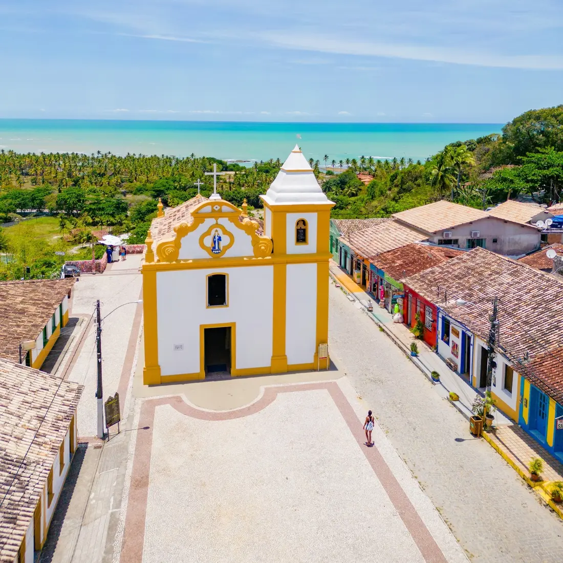 Igreja histórica de Arraial d'Ajuda com o mar ao fundo